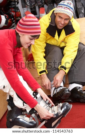 Couple On Trying On Ski Boots In Hire Shop