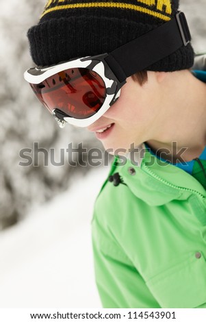 Teenage Boy Wearing Ski Goggles On Ski Holiday In Mountains