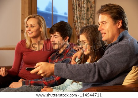 Portrait Of Family Relaxing On Sofa Together Watching TV