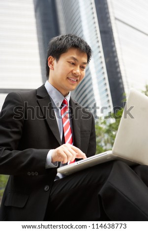 Chinese Businessman Working On Laptop Outside Office