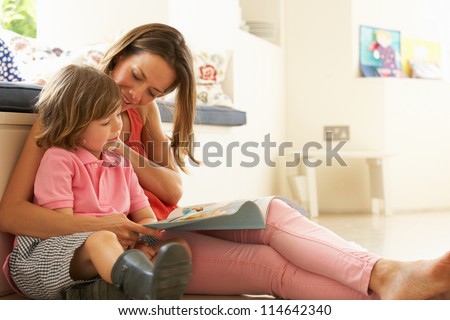 Mother Sitting With Son Reading Story Indoors