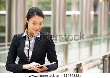 Chinese Businesswoman Working On Tablet Computer Outside Office