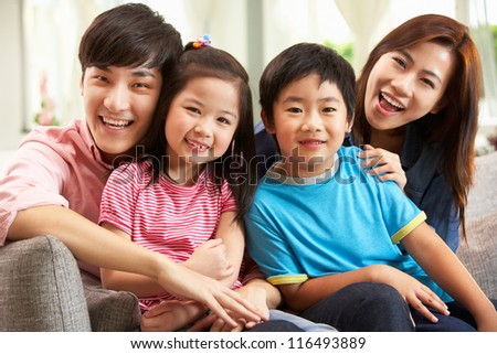 Chinese Family Relaxing On Sofa At Home