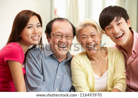Portrait Of Chinese Parents With Adult Children Relaxing At Home Together