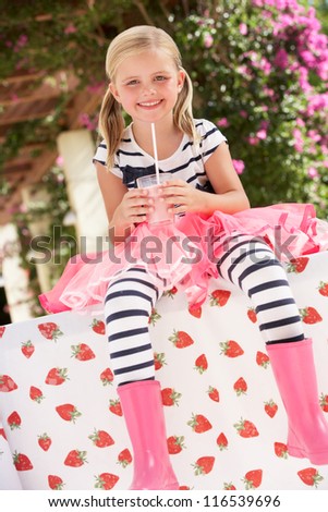 Young Girl Wearing Pink Wellington Boots Drinking Milkshake
