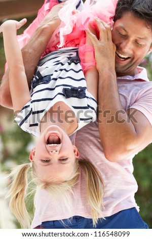 Father Holding Daughter Upside Down Outdoors