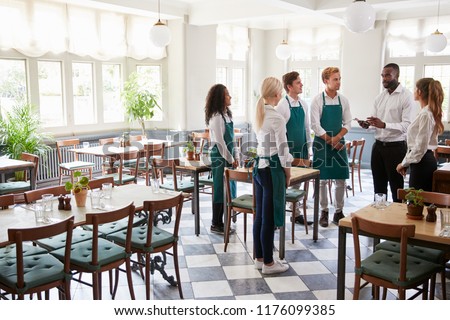 Staff Attending Team Meeting In Empty Dining Room