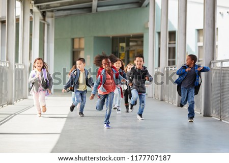Elementary school kids running in a corridor in the school