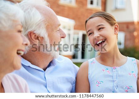 Granddaughter Talking With Grandparents During Visit To Retirement Home