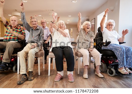 Senior Woman Winning Game Of Bingo In Retirement Home