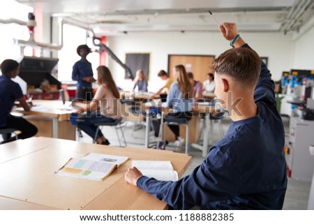 Male High School Student Asking Teacher Question In Design And Technology Lesson