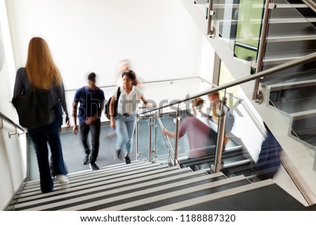 Motion Blur Shot Of High School Students Walking On Stairs Between Lessons In Busy College Building