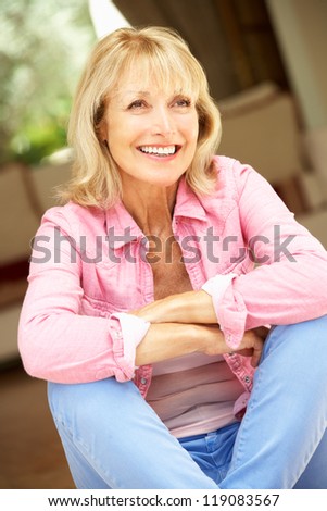 Senior Woman Sitting Outside House
