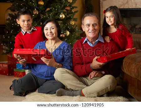 Grandparents With Grandchildren In Front Of Christmas Tree