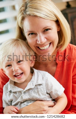 Portrait Of Mother And Son Sitting On Sofa At Home