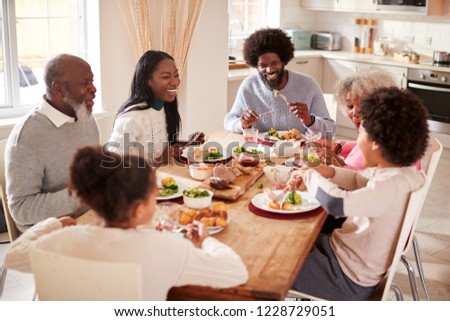 Multi generation mixed race family eating their Sunday dinner together at home, elevated view