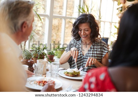 White adult woman eating with friends at a cafe, close up