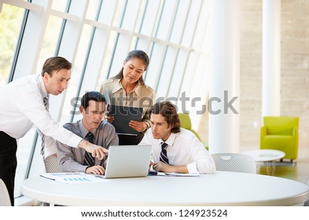 Businesspeople Having Meeting Around Table In Modern Office
