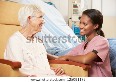 Nurse talking to female teenage patient in hospital 