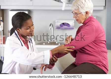 Doctor Examining Female Patient With Elbow Pain