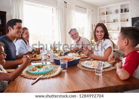 Three generation Hispanic family sitting at the table eating dinner