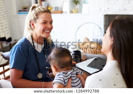 Female healthcare worker visiting a young mum and her infant son at home, close up