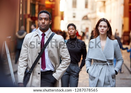 Millennial business people walking in a London street, front view, close up
