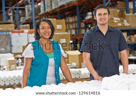 Factory Workers Checking Goods On Production Line