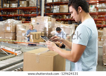 Worker Using Tablet Computer In Distribution Warehouse Worker Using Tablet Computer In Distribution Warehouse