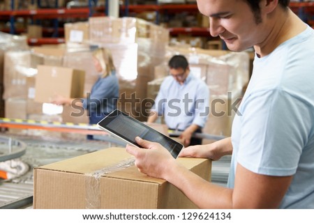 Worker Using Tablet Computer In Distribution Warehouse
