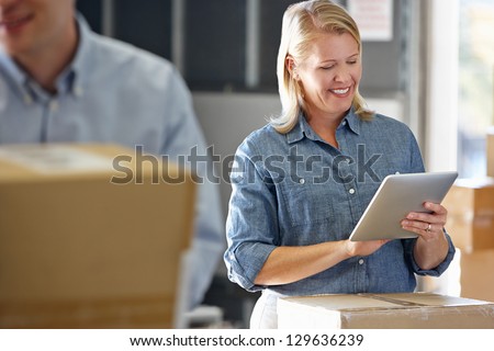 Manager Using Tablet Computer In Distribution Warehouse Manager Using Tablet Computer In Distribution Warehouse