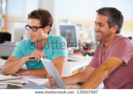 Two Men Using Tablet Computer In Creative Office