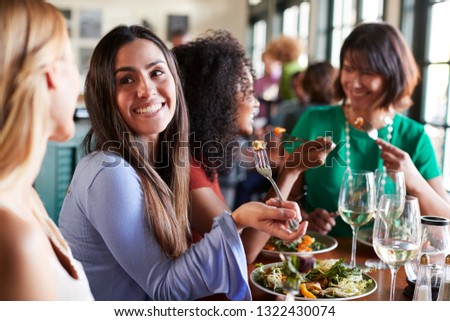 Group Of Female Friends Enjoying Meal In Restaurant Together