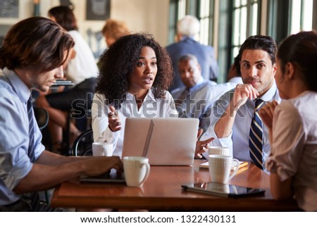 Business Team Having Informal Meeting Around Table In Coffee Shop