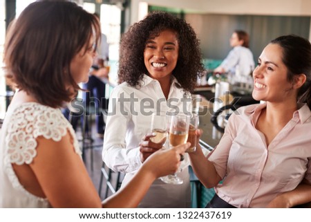 Three Businesswoman Meeting For After Works Drinks In Bar Making A Toast