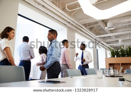 Group Of Business Colleagues Chatting In Office After Meeting