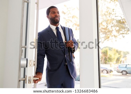 Businessman Wearing Suit Opening Door Returning Home From Work