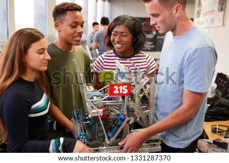 University Students Carrying Machine In Science Robotics Or Engineering Class