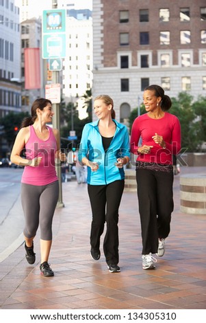 Group Of Women Power Walking On Urban Street