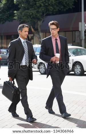 Two Businessman Chatting Whilst Crossing Street