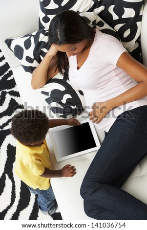 Overhead View Of Mother And Son On Sofa Using Digital Tablet