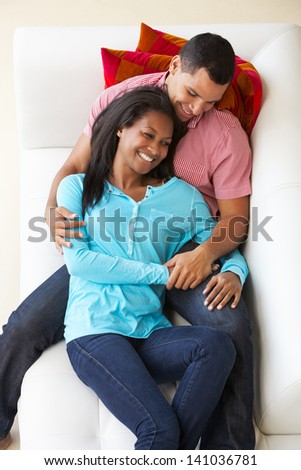 Overhead View Of Couple Relaxing On Sofa Watching Television