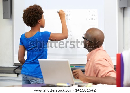 Female Student Writing Answer On Whiteboard
