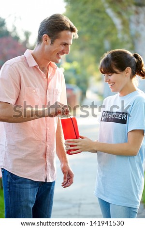 Charity Worker Collecting From Man In Street