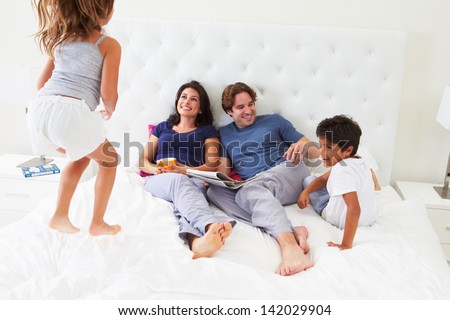 Children Jumping On Parents Bed Wearing Pajamas