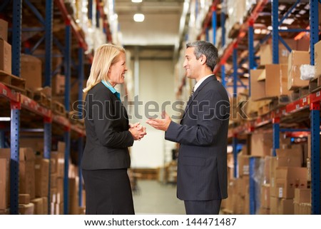 Businesswoman And Businessman In Distribution Warehouse