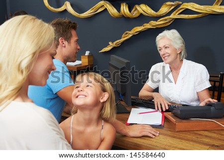Hotel Receptionist Helping Family To Check In