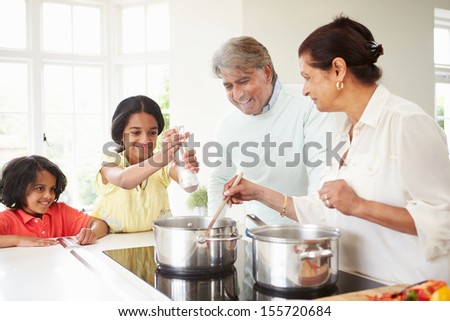 Grandparents And Grandchildren Cooking Meal At Home