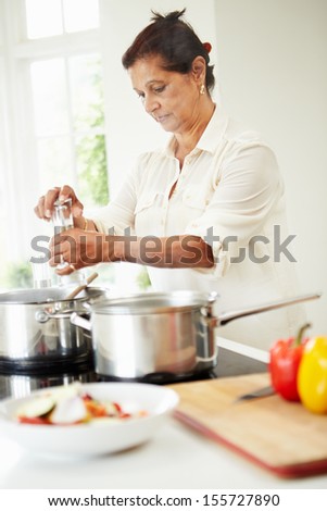 Senior Indian Woman Cooking Meal At Home