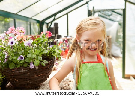 Girl Growing Plants In Greenhouse